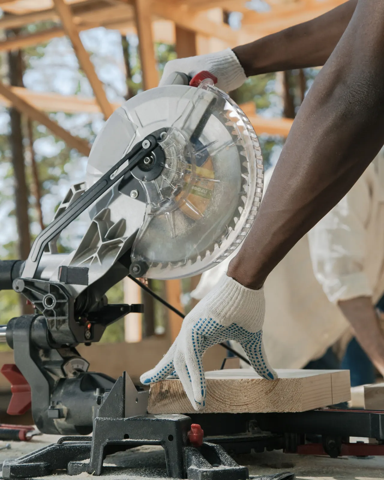 Carpenter measuring and cutting lumber on a job site